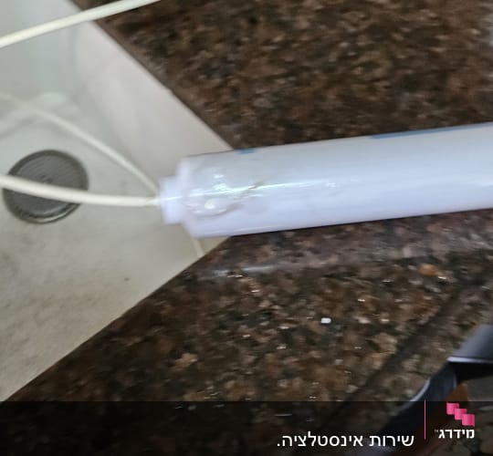 כיור מטבח עם צינור מים וכלי עבודה
